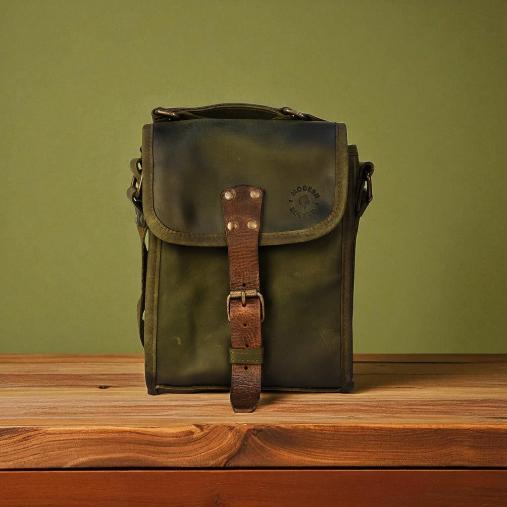 Green leather bag with a brown strap on a wooden surface against a green background