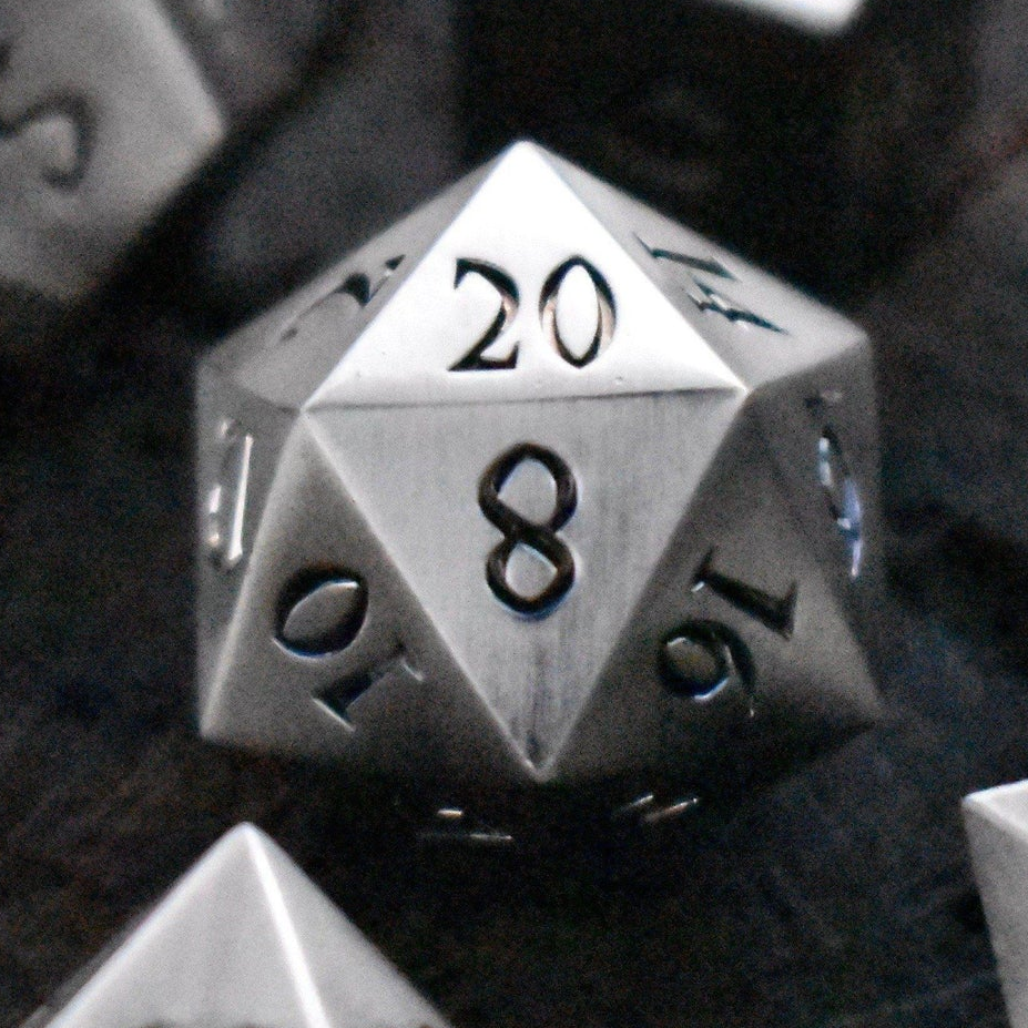 Close-up of a silver polyhedral dice with black numbers on a dark background