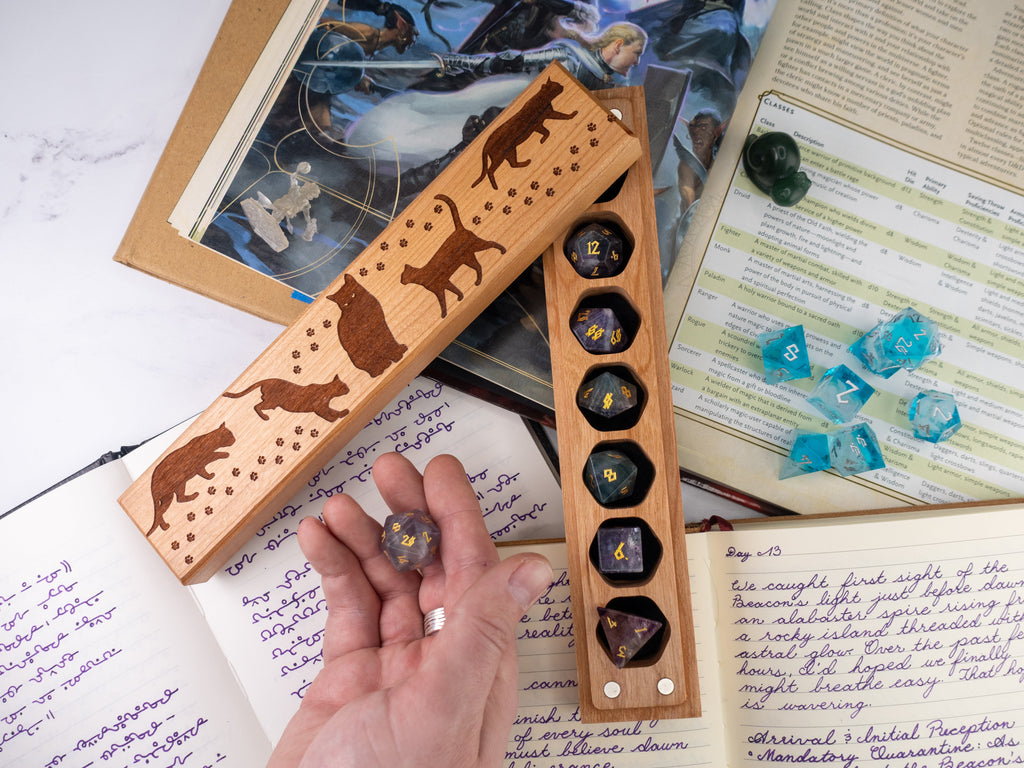 Wooden dice holder with animal designs on a table with gaming materials