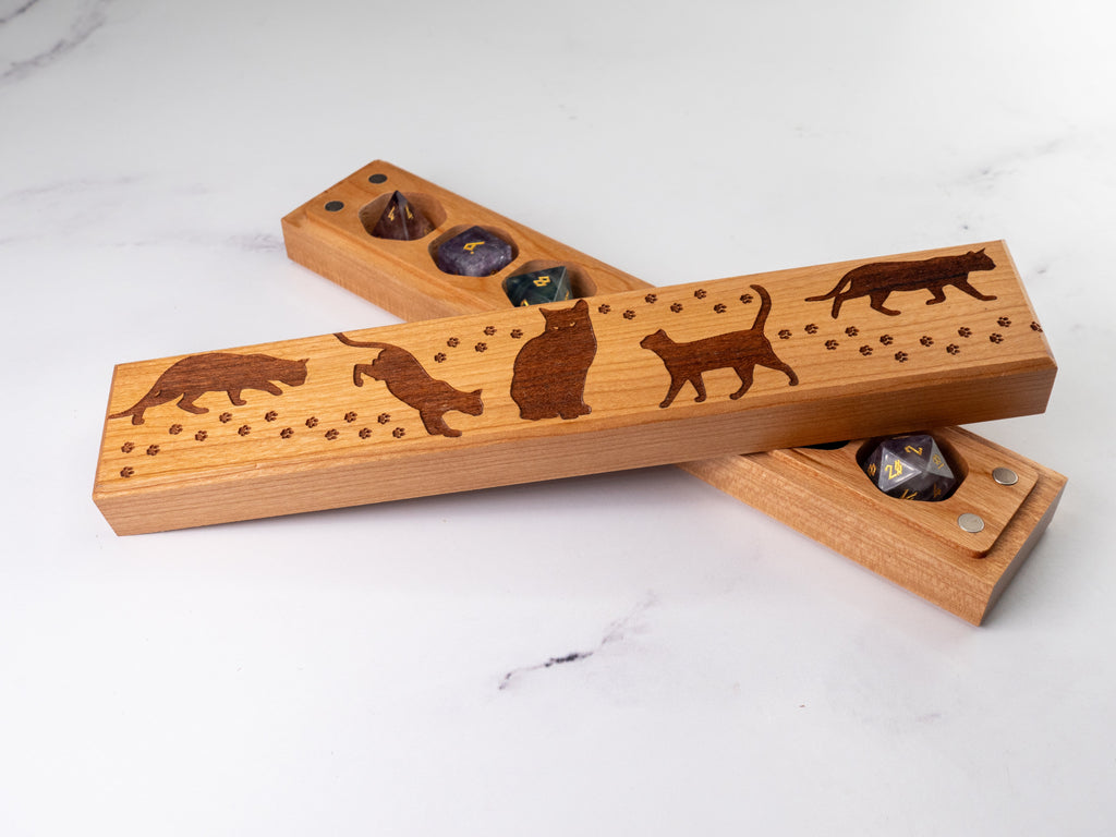 Wooden dice tray with cat designs on a white surface