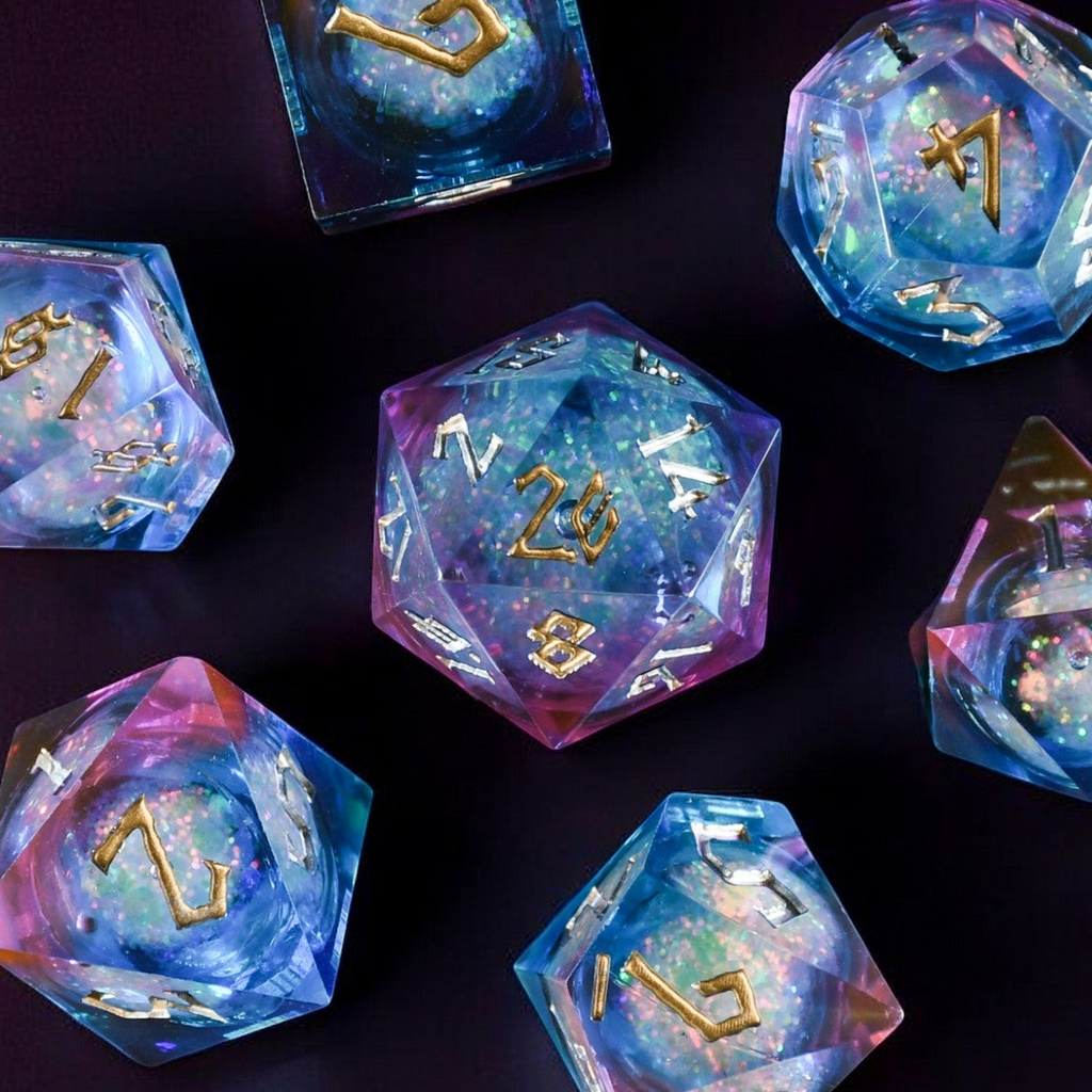 A set of resin dice with a liquid core, featuring a celestial galaxy pattern, laid out on a dark background.