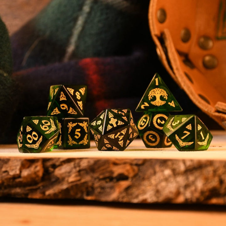 a set of polyhedral Celtic Green Glass Dice with golden numbering and celtic designs