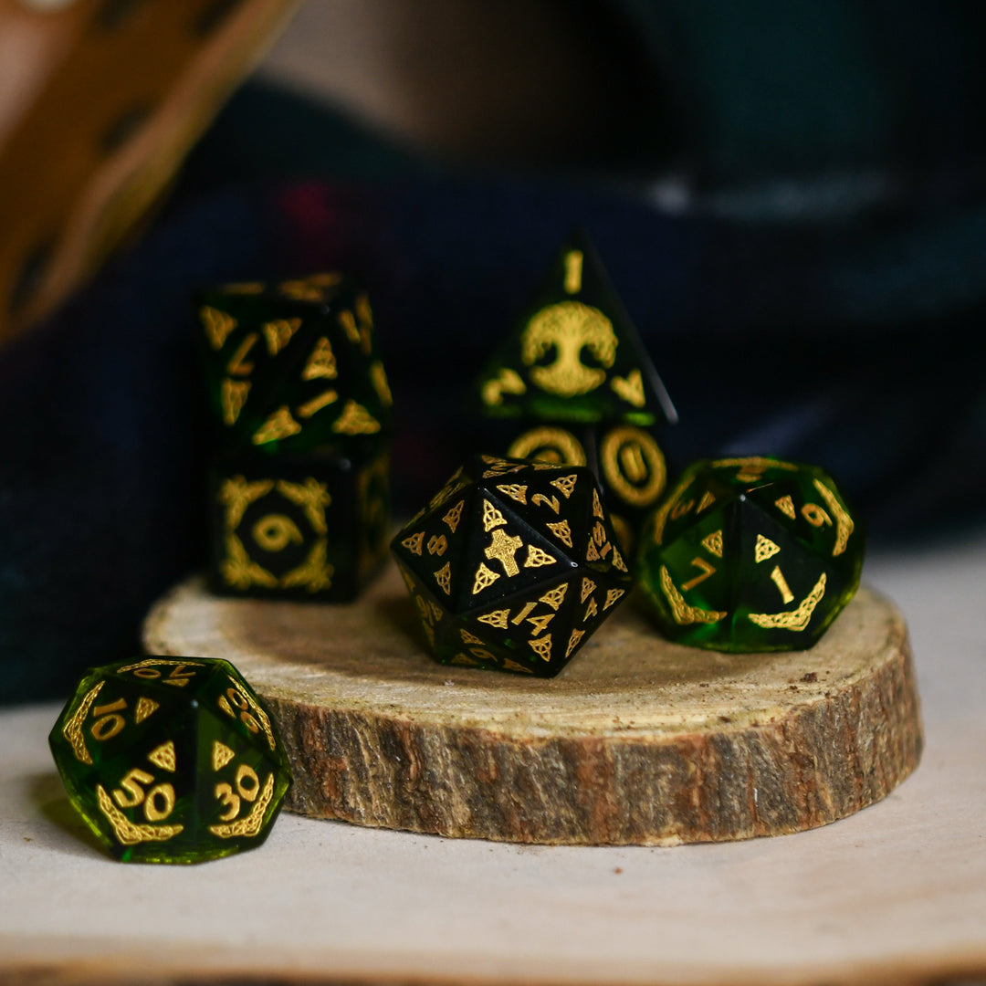 a set of polyhedral Celtic Green Glass Dice with golden numbering and celtic designs