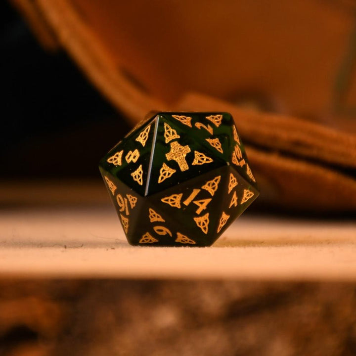 a set of polyhedral Celtic Green Glass Dice with golden numbering and celtic designs
