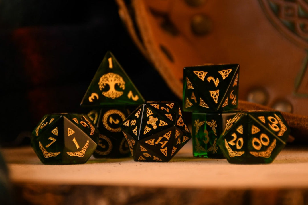 a set of polyhedral Celtic Green Glass Dice with golden numbering and celtic designs
