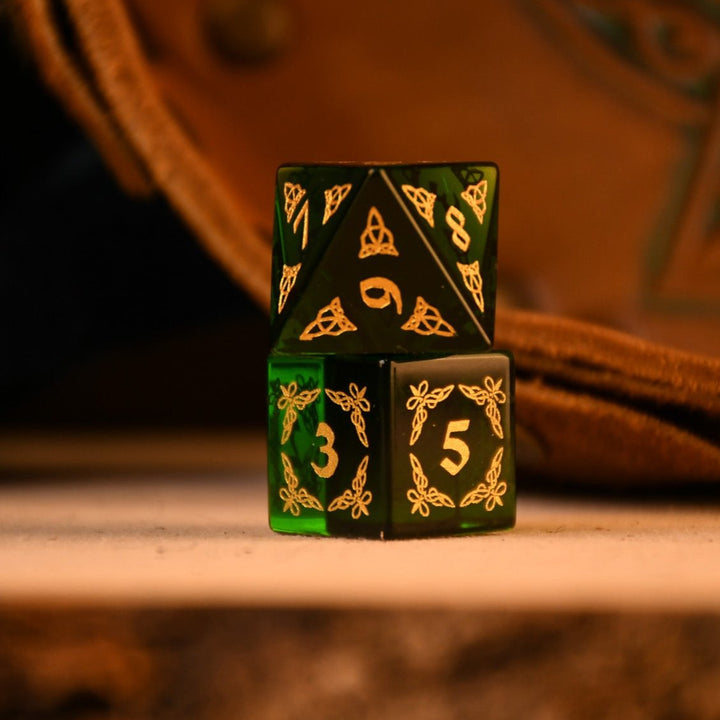 a set of polyhedral Celtic Green Glass Dice with golden numbering and celtic designs