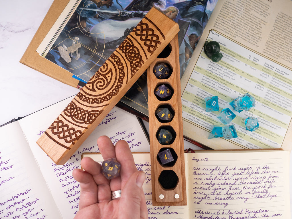Wooden dice holder with dice on a table with gaming materials