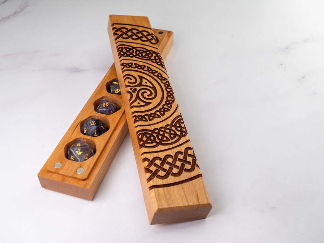Wooden dice holder with Celtic knot designs on a white background