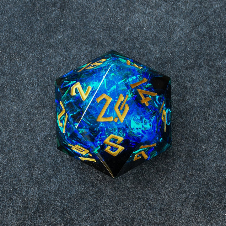 A hand-crafted, sharp-edged resin dice with hand-painted numbers, predominantly blue in color, used for tabletop RPG games.