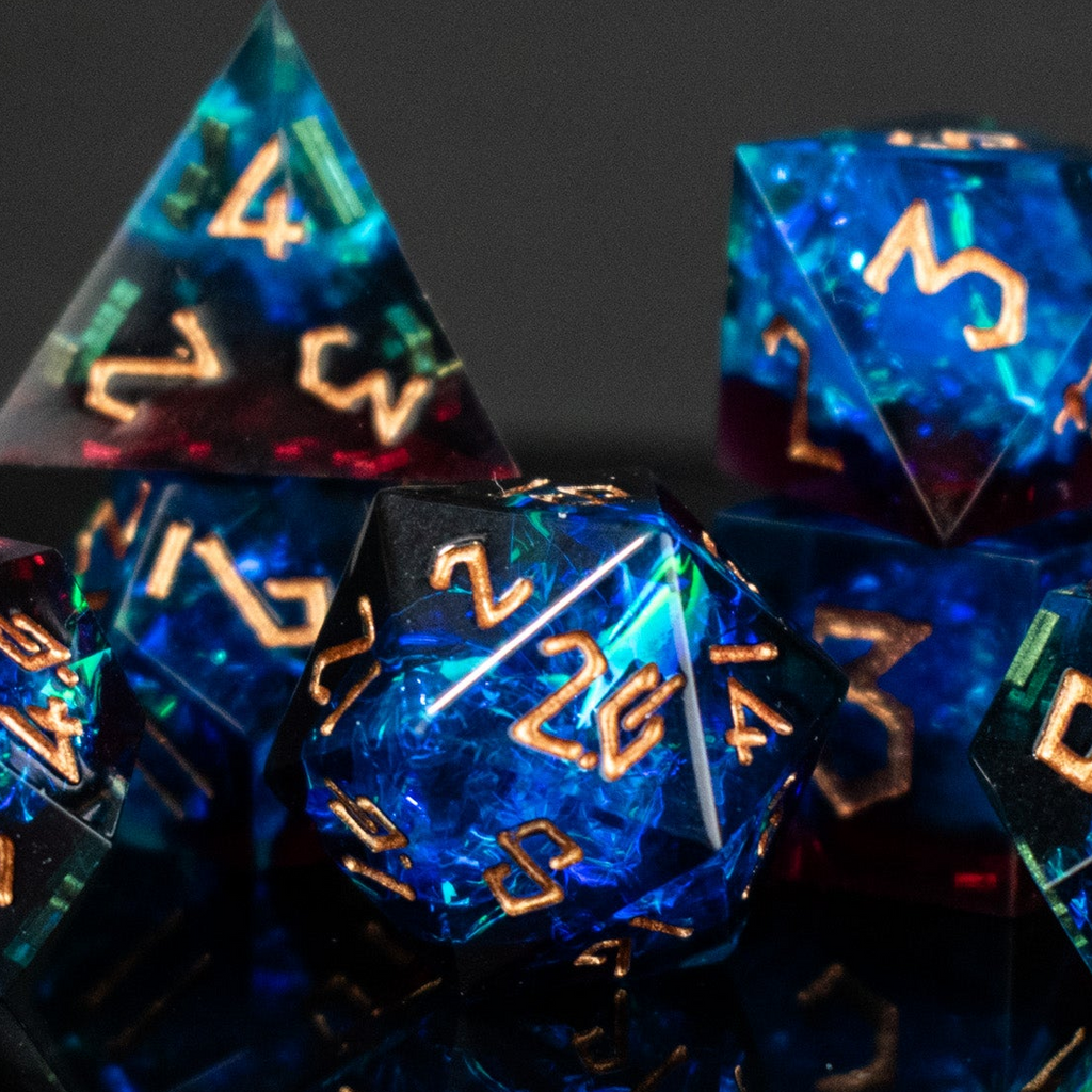 A set of sharp-edged, multicolored resin dnd dice with gold engraved numbers, reflecting on a surface.