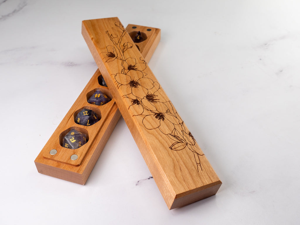 Wooden dice tray with floral engravings on a white background