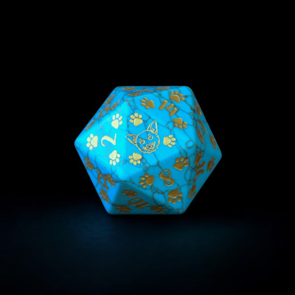 A hand-carved gemstone D20 dice with green turquoise coloring and decorative elements in the form of a puppy paw and bone on one of the faces,