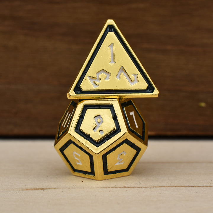 gold polyhedral metal dnd dice with black borders on each face and white numbering