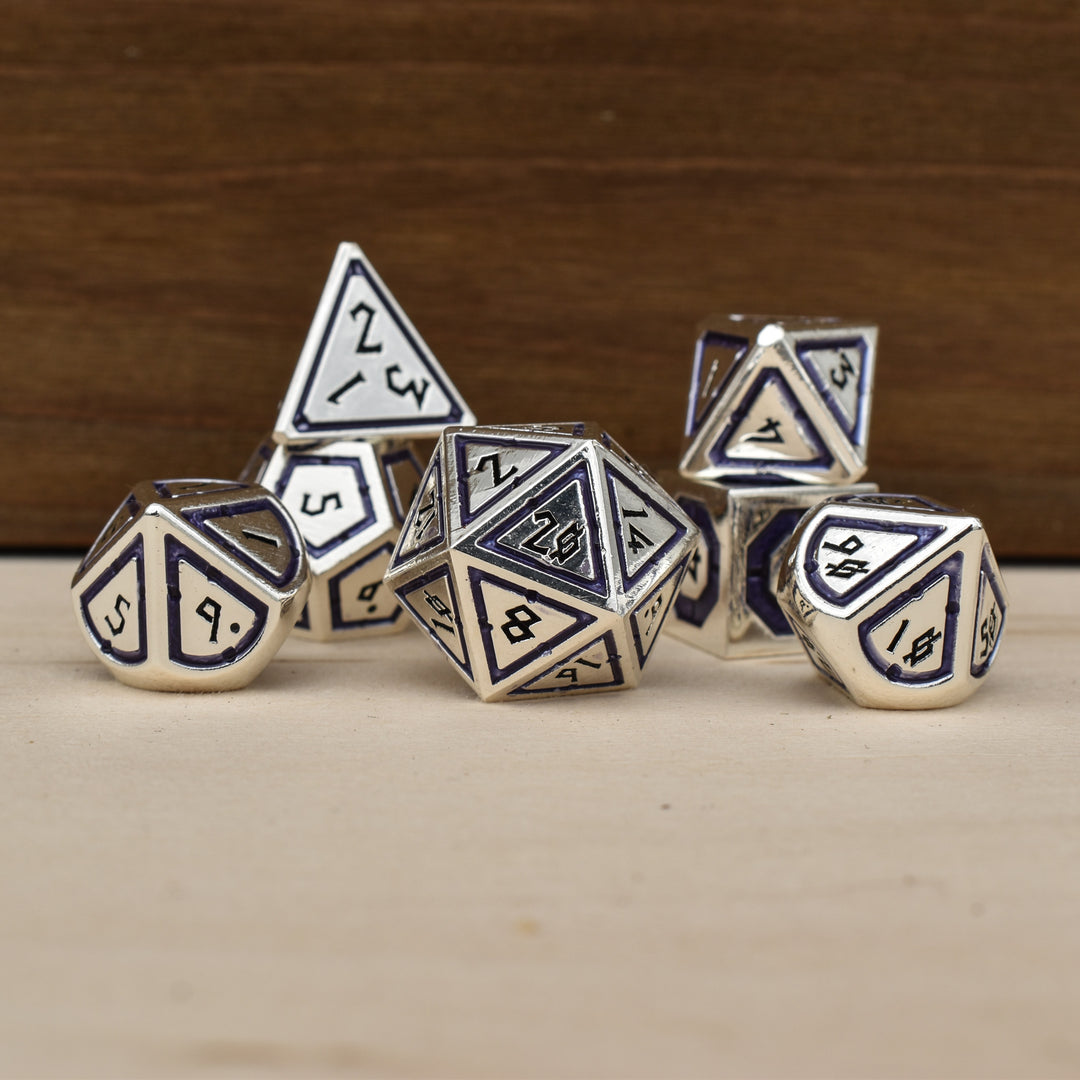 A set of silver polyhedral metal dnd dice with deep purple borders on each face and black numbering