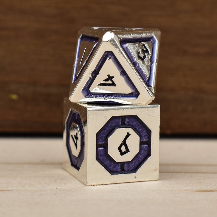 A set of silver polyhedral metal dnd dice with deep purple borders on each face and black numbering