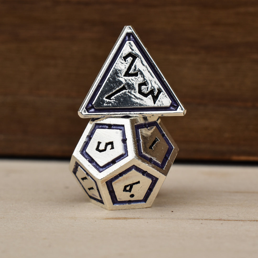 A set of silver polyhedral metal dnd dice with deep purple borders on each face and black numbering
