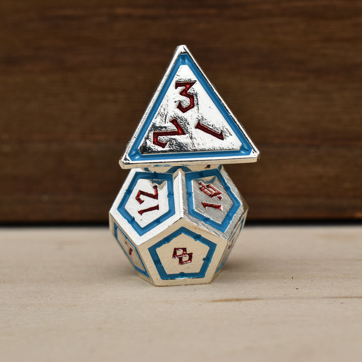 silver polyhedral metal dnd dice with blue borders on each face and red numbering