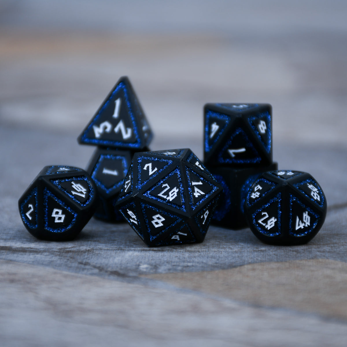 black metal polyhedral dnd dice with blue glittery borders and white numbering