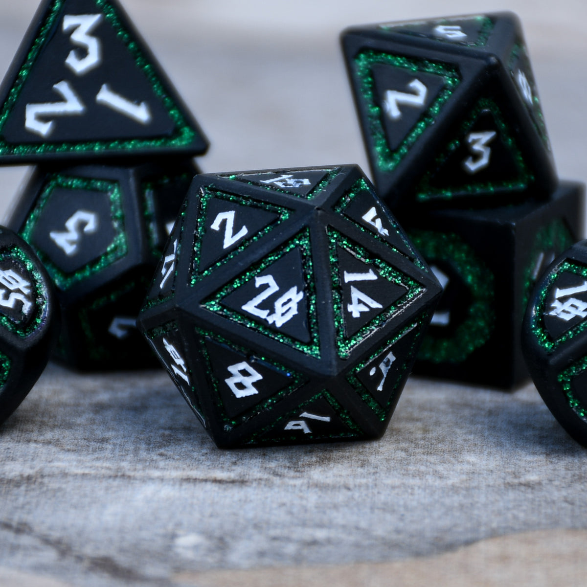 black d20 die with white numbering and deep green glitter border on each face