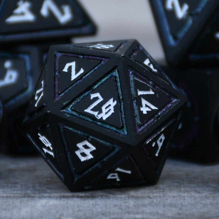 Black polyhedral dice with white lettering on a textured surface