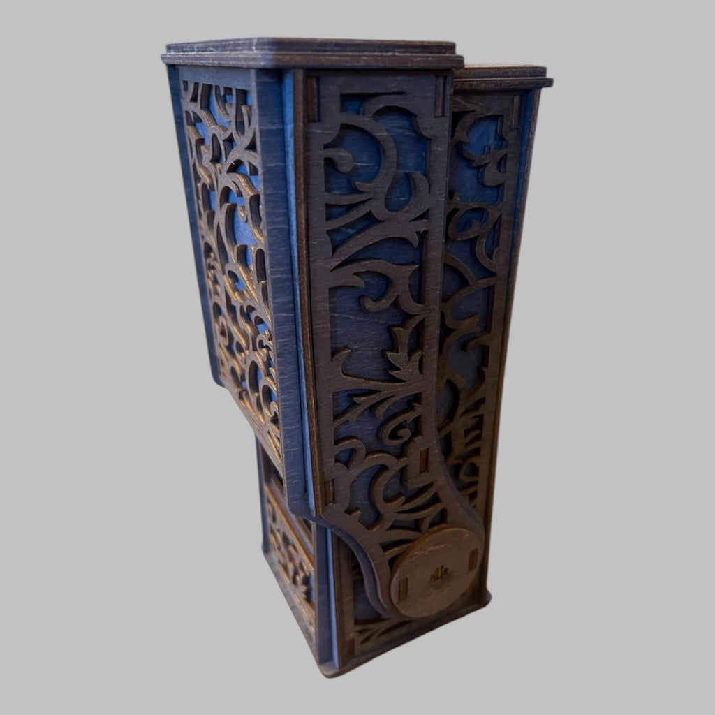 A collapsible blue dice tower with intricate patterns, made of wood, with a magnetic drawer.