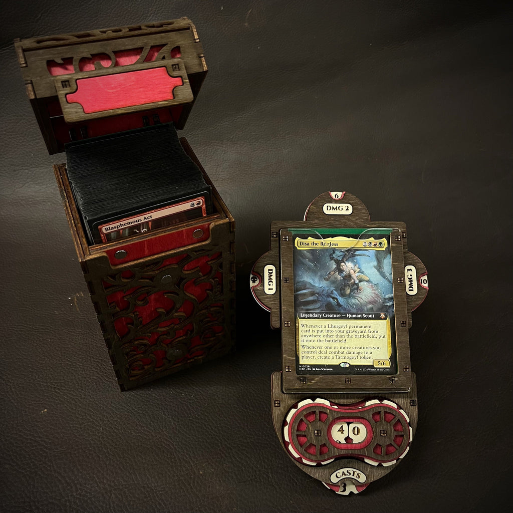 A wooden deck box with intricate cut-out patterns, featuring a purple interior, accompanied by a command plate and game tokens.