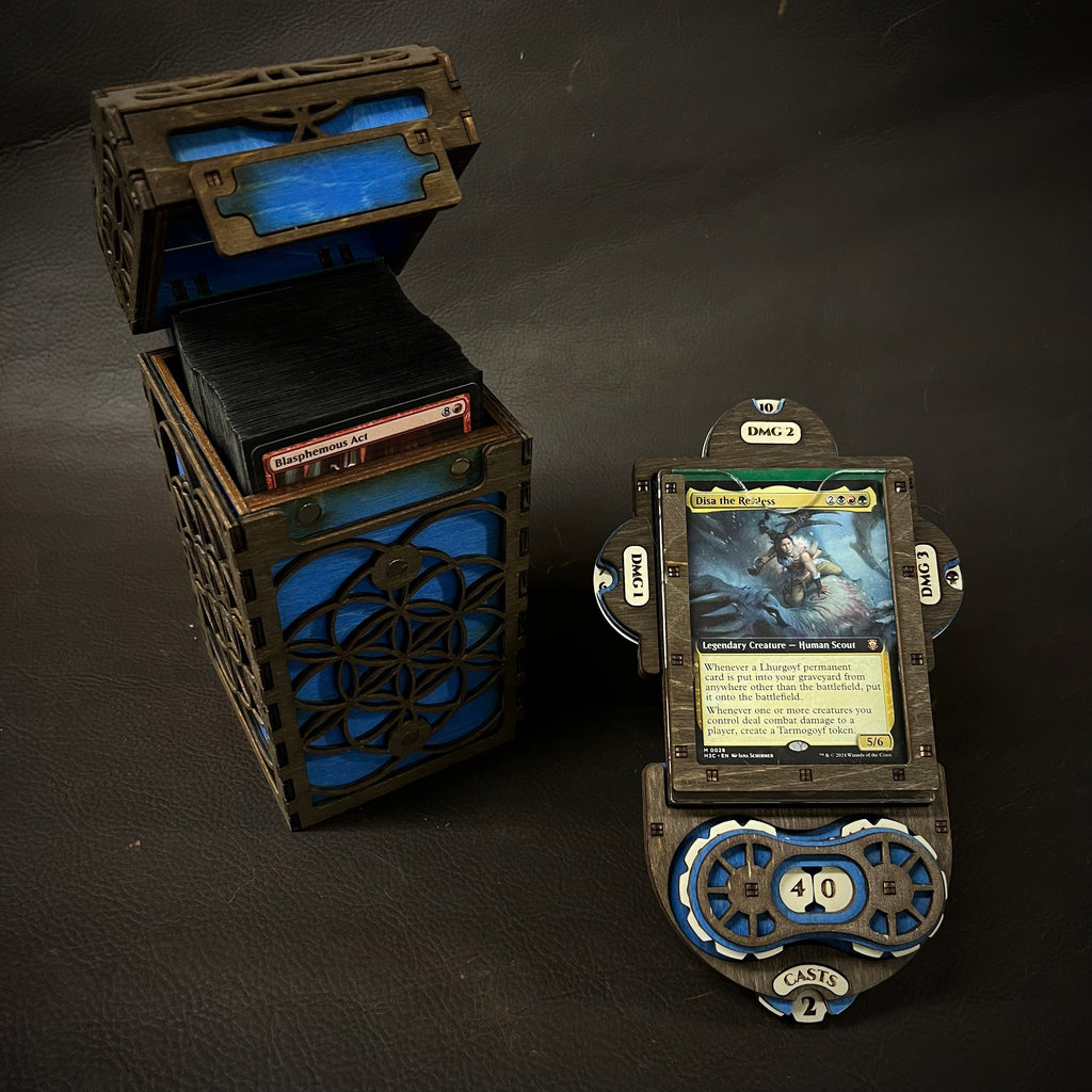 A wooden deck box with intricate cut-out patterns, featuring a purple interior, accompanied by a command plate and game tokens.