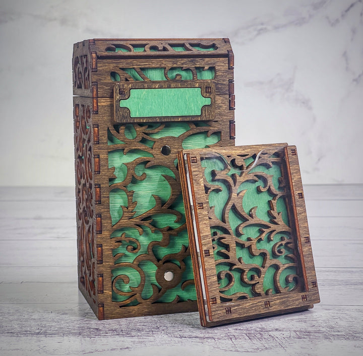 A wooden deck box with a intricate carved design, featuring a removable magnetic plate on the front for holding cards from the game &