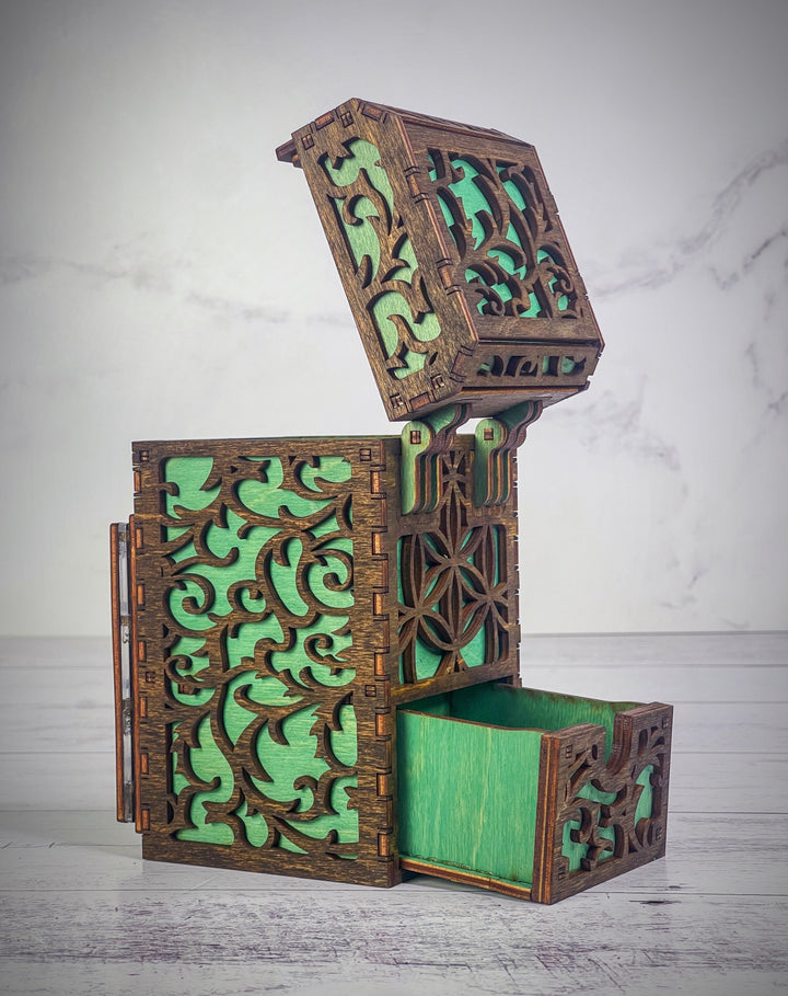 A wooden deck box with a intricate carved design, featuring a removable magnetic plate on the front for holding cards from the game &