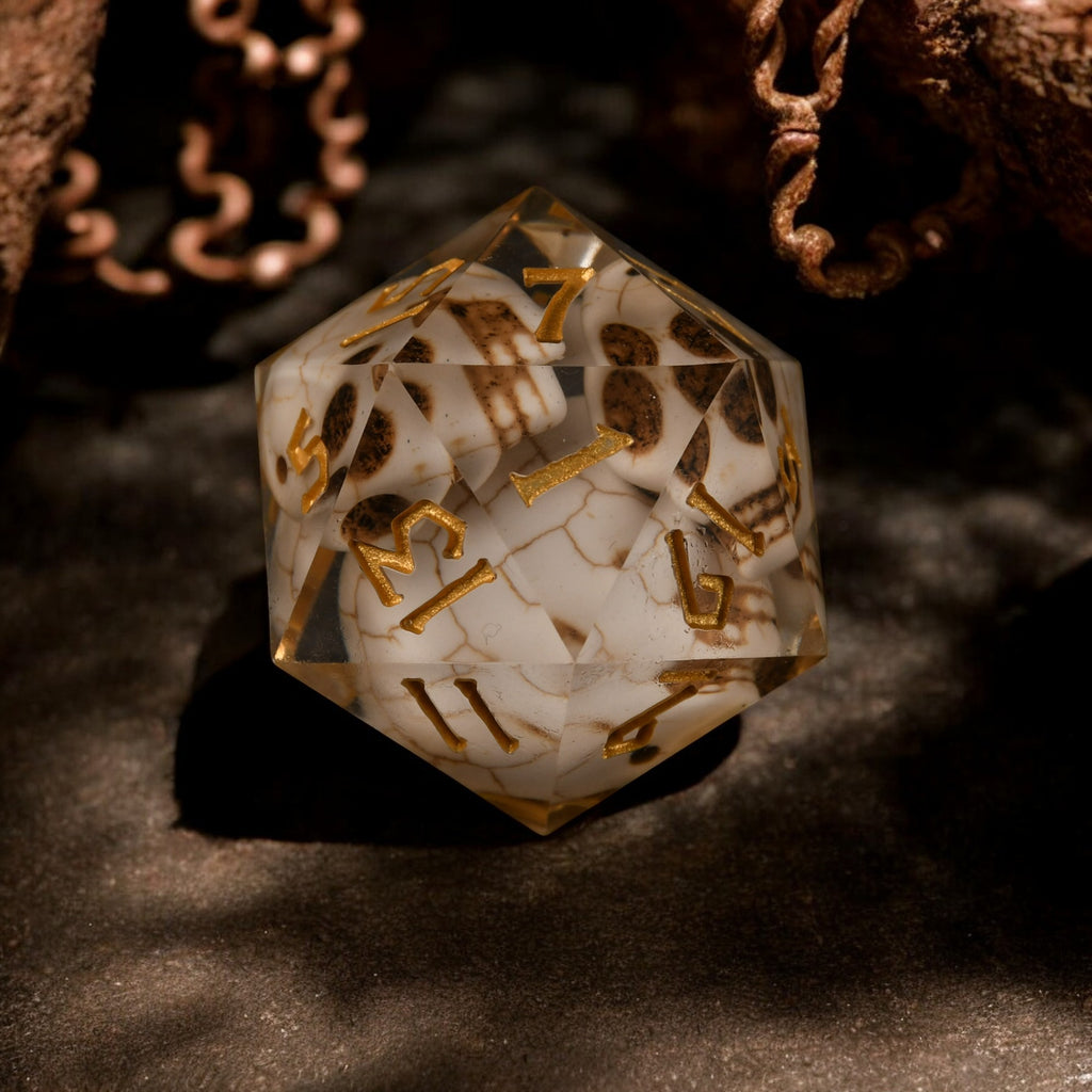 A hand-crafted, hand-painted 30mm resin dice with black, gold, and white colors designed to look like a skull, suitable for tabletop RPG games.