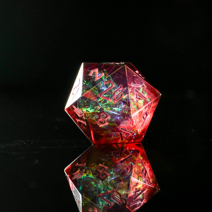 A set of sharp-edged, multicolored resin dice with hand-painted numbers, reflecting on a surface with a colorful backdrop.