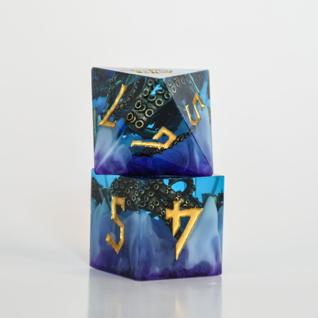 Blue and purple sharp edge resin dnd dice with bronze cthulhu tentacles inside and gold numbering