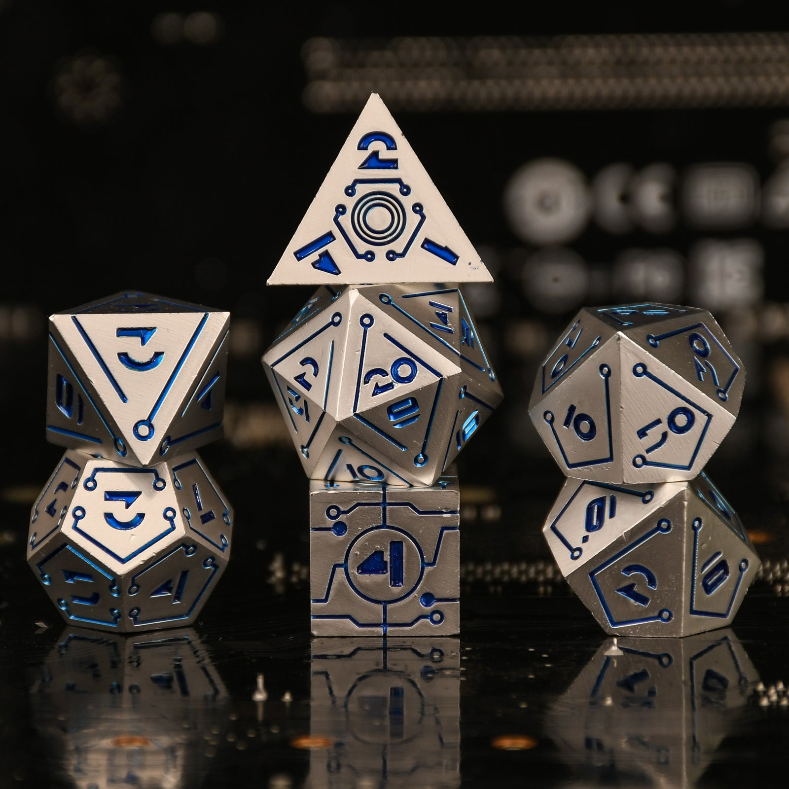 a set of matte silver cyberpunk inspired metal dnd dice with blue numbering and detail on a blurry computer chip inspired background