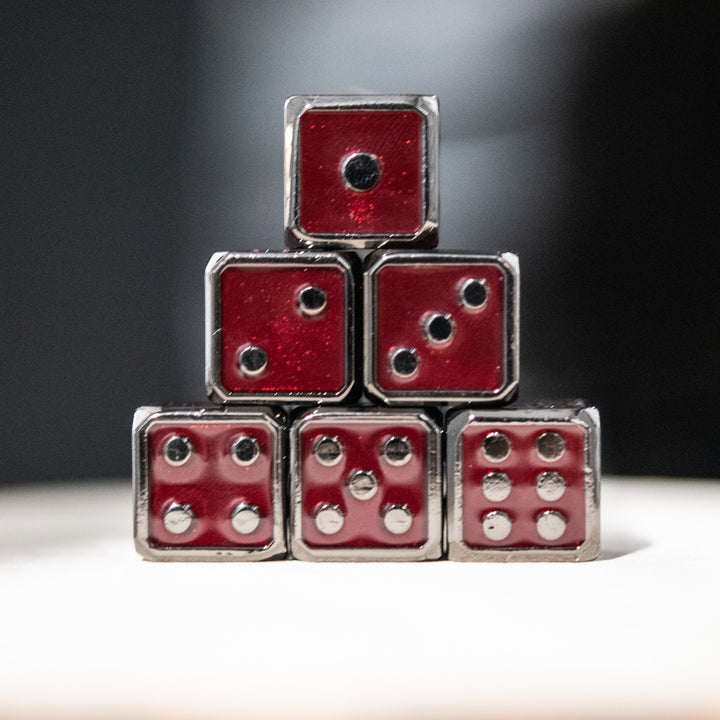 six red and black metal d6 dice with embossed numbers, representing a complete set.