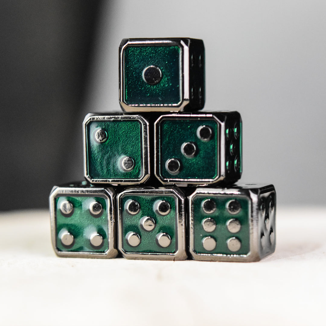 A stack of six green metal dice with black pips