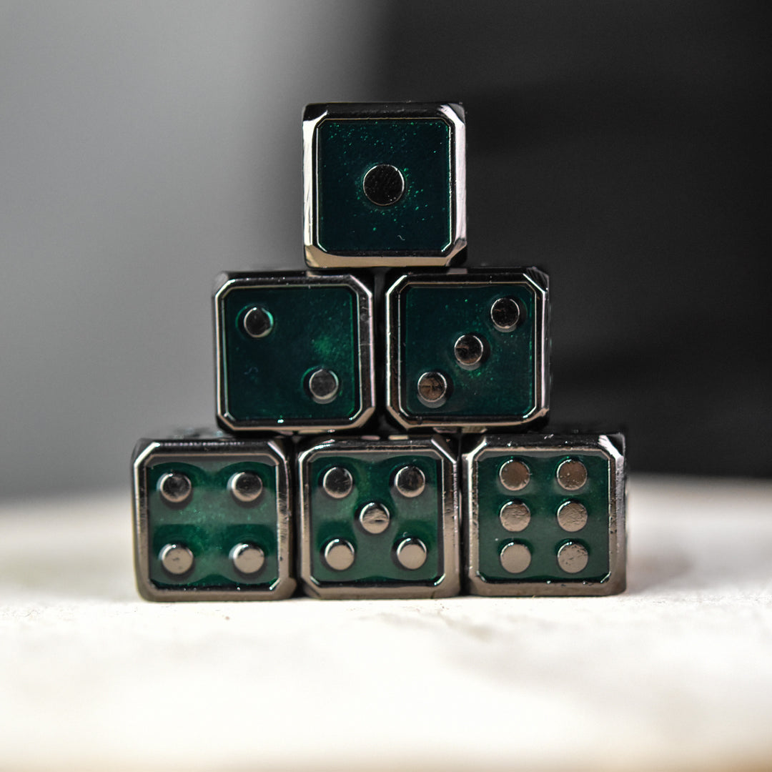 A stack of six green metal dice with black pips