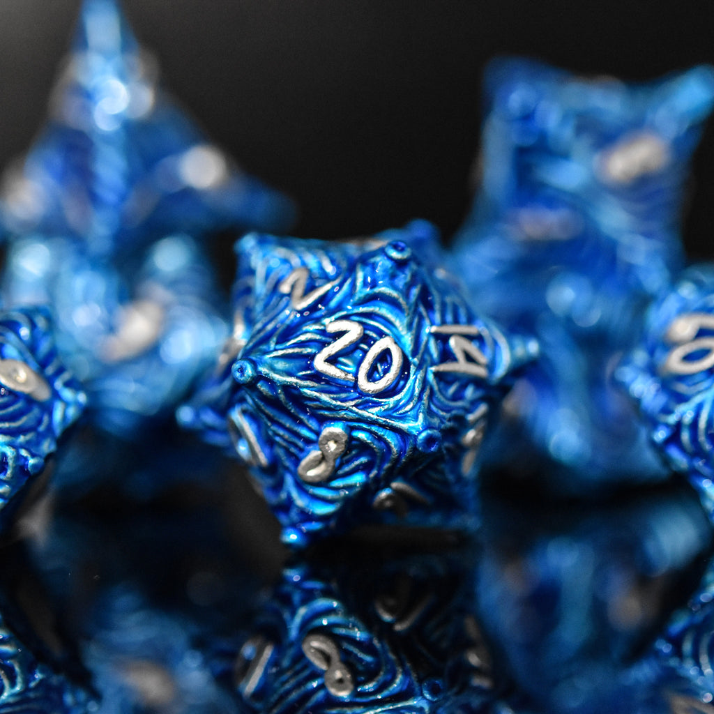 Blue metal dice with vortex swirls and a silver font