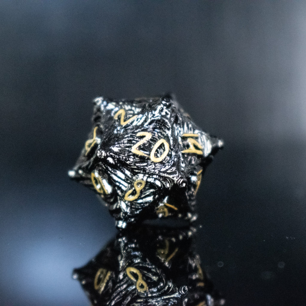 Black metal D20 with vortex swirls and a gold font
