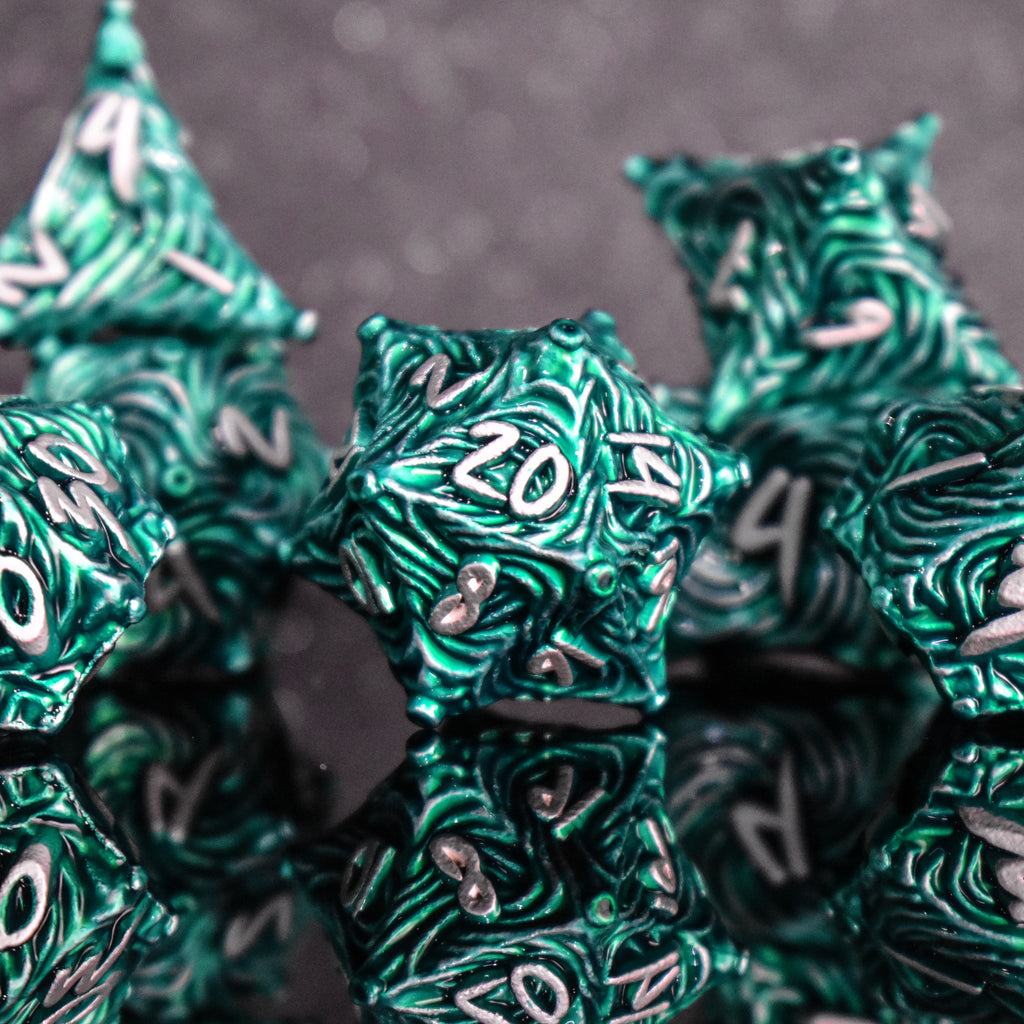 Green metal dice with vortex swirls and a white font