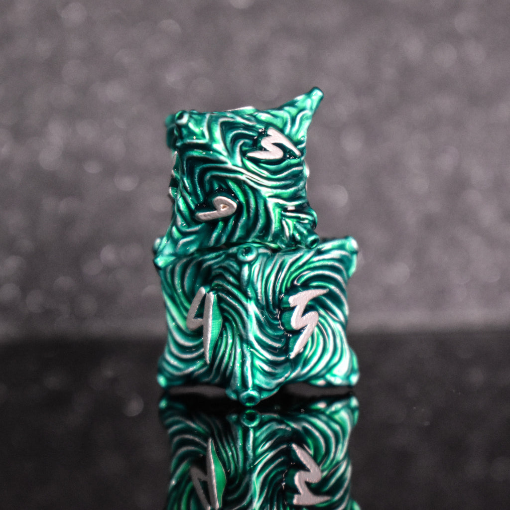 Green metal dice with vortex swirls and a white font