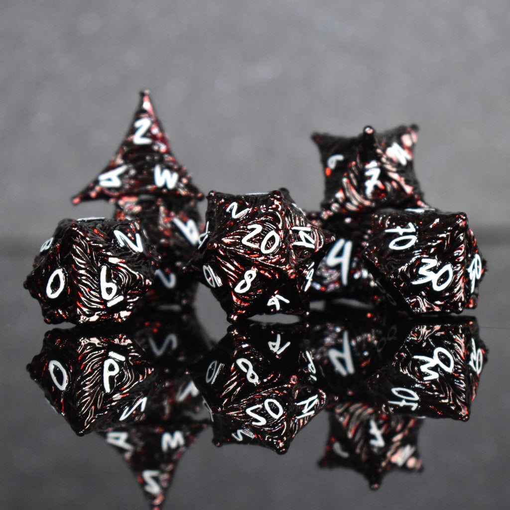 Deep red metal dice with vortex swirls and a white font