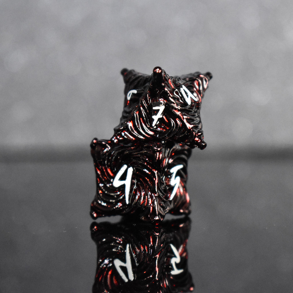 Deep red metal dice with vortex swirls and a white font