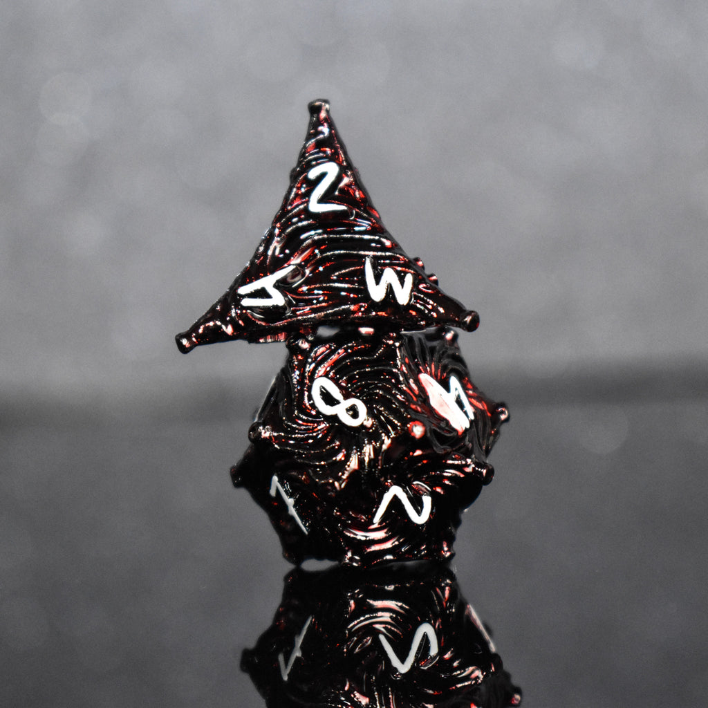 Deep red metal dice with vortex swirls and a white font