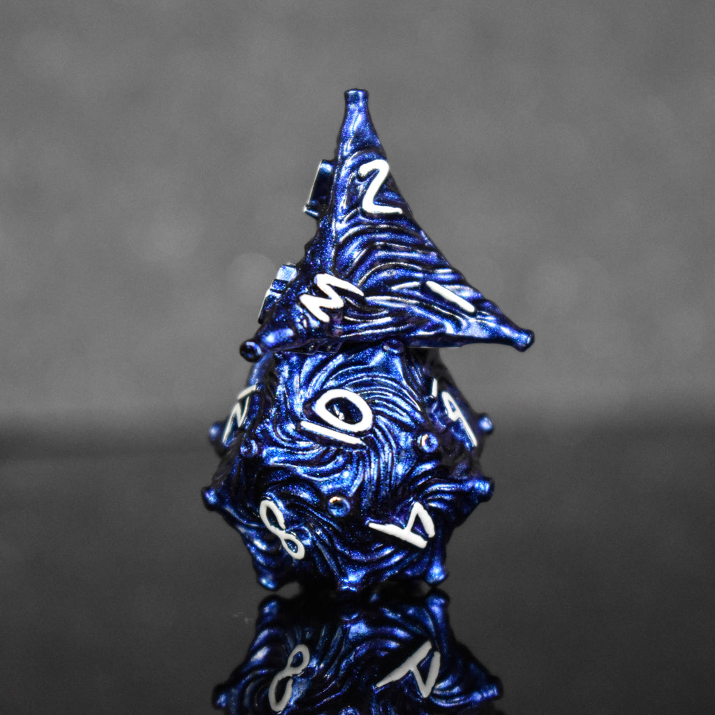 Dark blue metal dice with vortex swirls and a white font