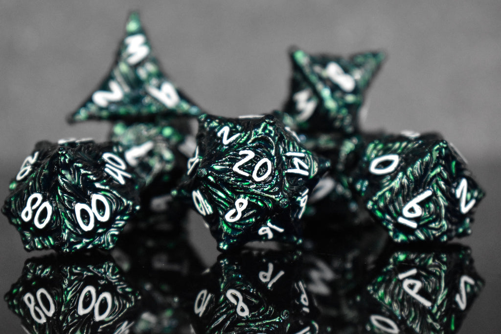 Dark green metal dice with vortex swirls and a white font
