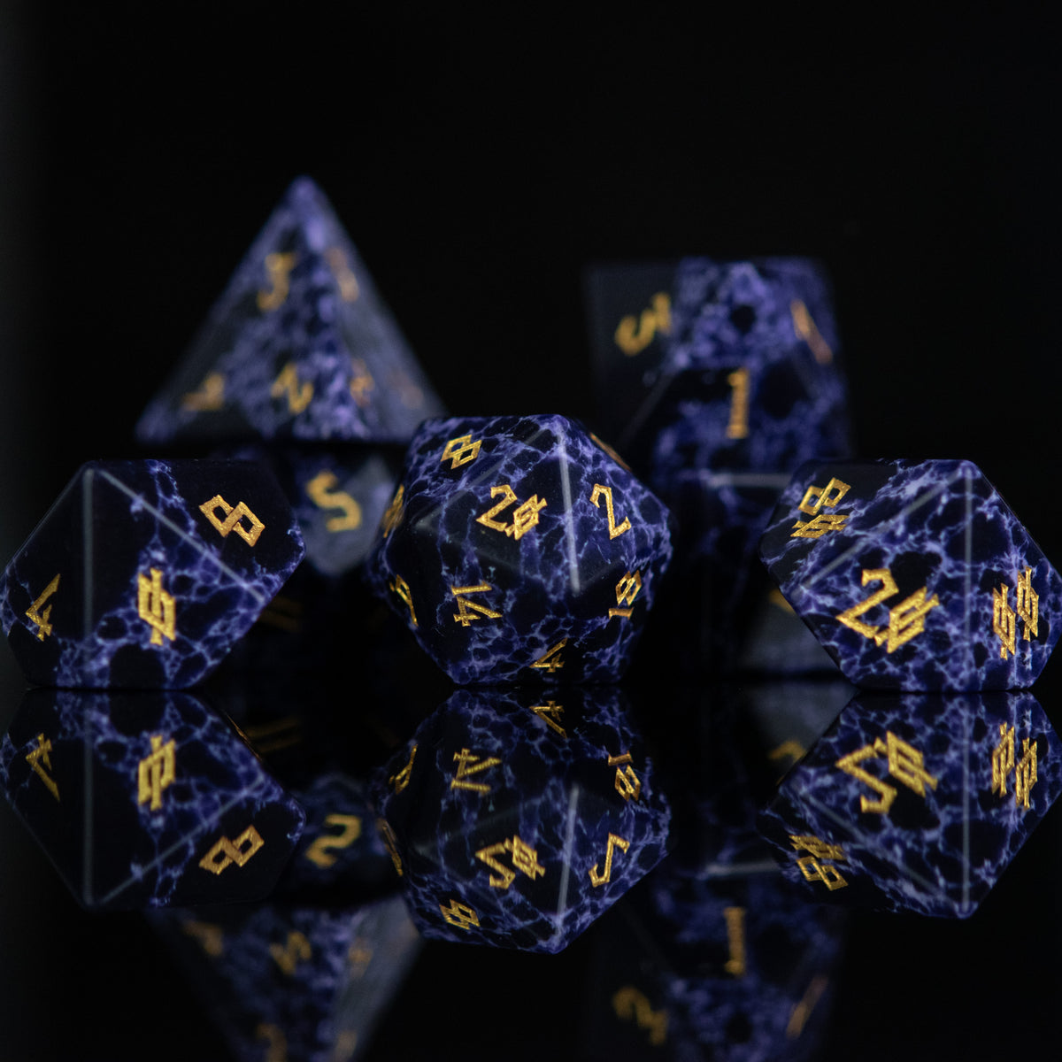 Black stone dice with blue lightning and gold nordic font numbers