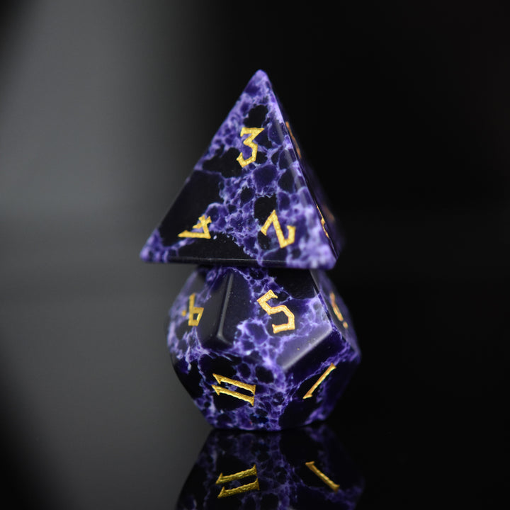 Black stone dice with blue lightning and gold nordic font numbers