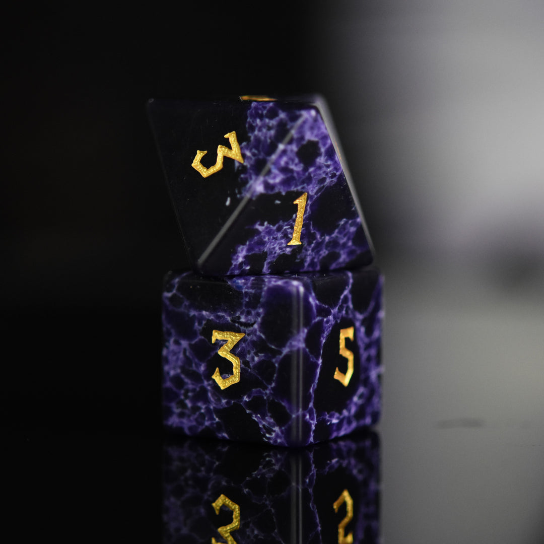 Black stone dice with blue lightning and gold nordic font numbers