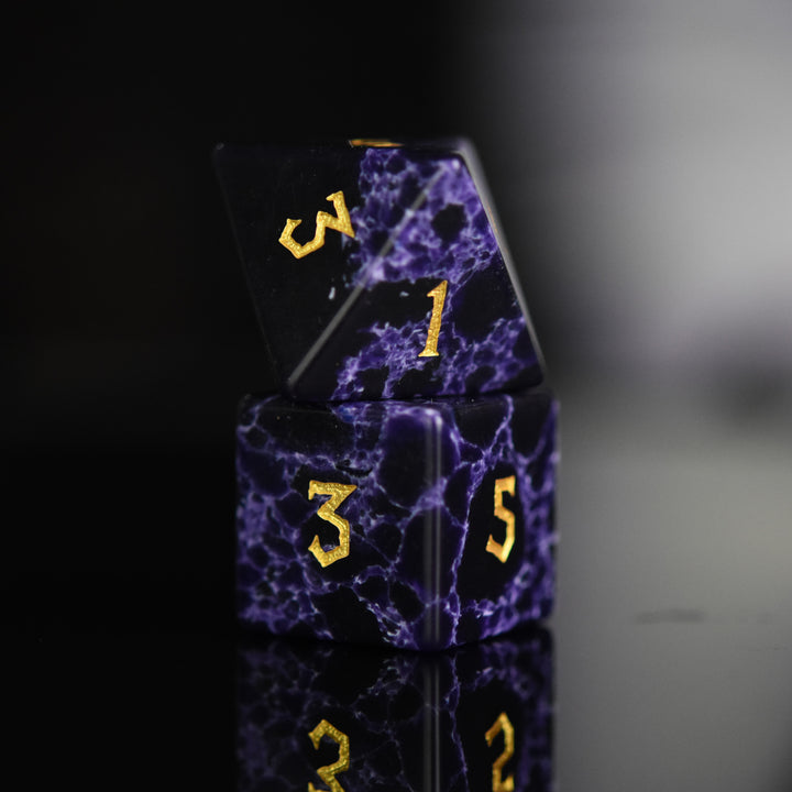 Black stone dice with blue lightning and gold nordic font numbers
