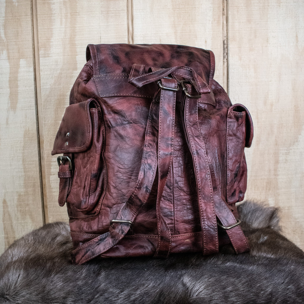 The back of a brown leather backpack 
